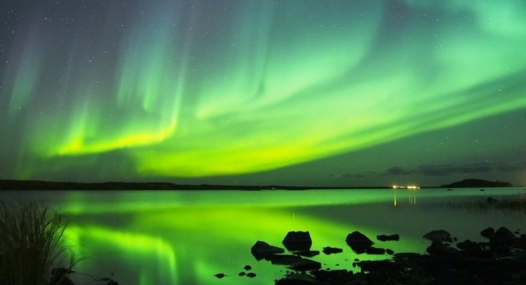 湖面に映る緑のオーロラと夜空の星が広がる風景で、レイキと自然エネルギーの静かな調和をイメージした写真