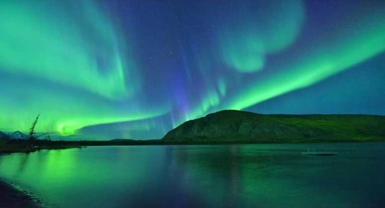 湖面に映るグリーンのオーロラと山並みが広がる夜空の風景で、レイキと自然エネルギーの静かな調和をイメージした写真