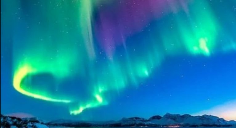 夜空に広がる紫と緑のオーロラと静かな海が調和する風景で、レイキと宇宙エネルギーの幻想的なつながりをイメージした写真